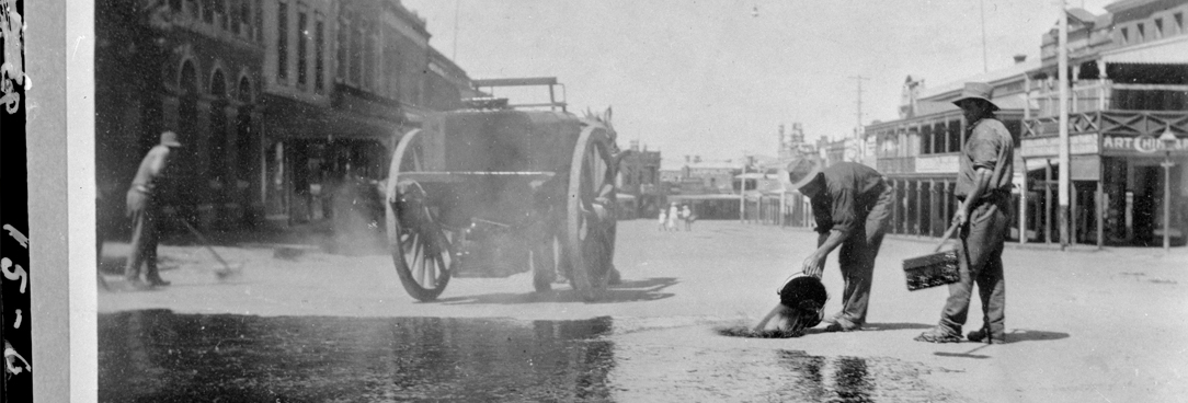 Vic Roads Collection black and white photo of men pouring water on road