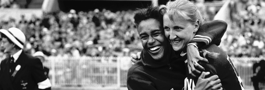 Women's Long Jump, 2nd placegetter W.B. White (USA) & winner E. Krzesinska (Poland) share a hug, Melbourne Olympics 1956, VPRS 10742 P0 Unit 8 Item A696 Photo of two women hugging in a stadium