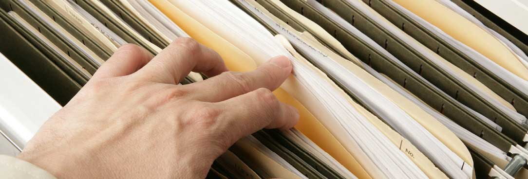 Stock Image hand searching suspension files