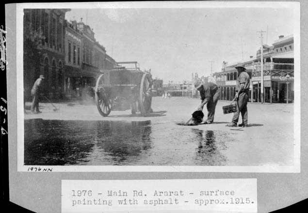 black and white photo of ashpalt being poured on a road