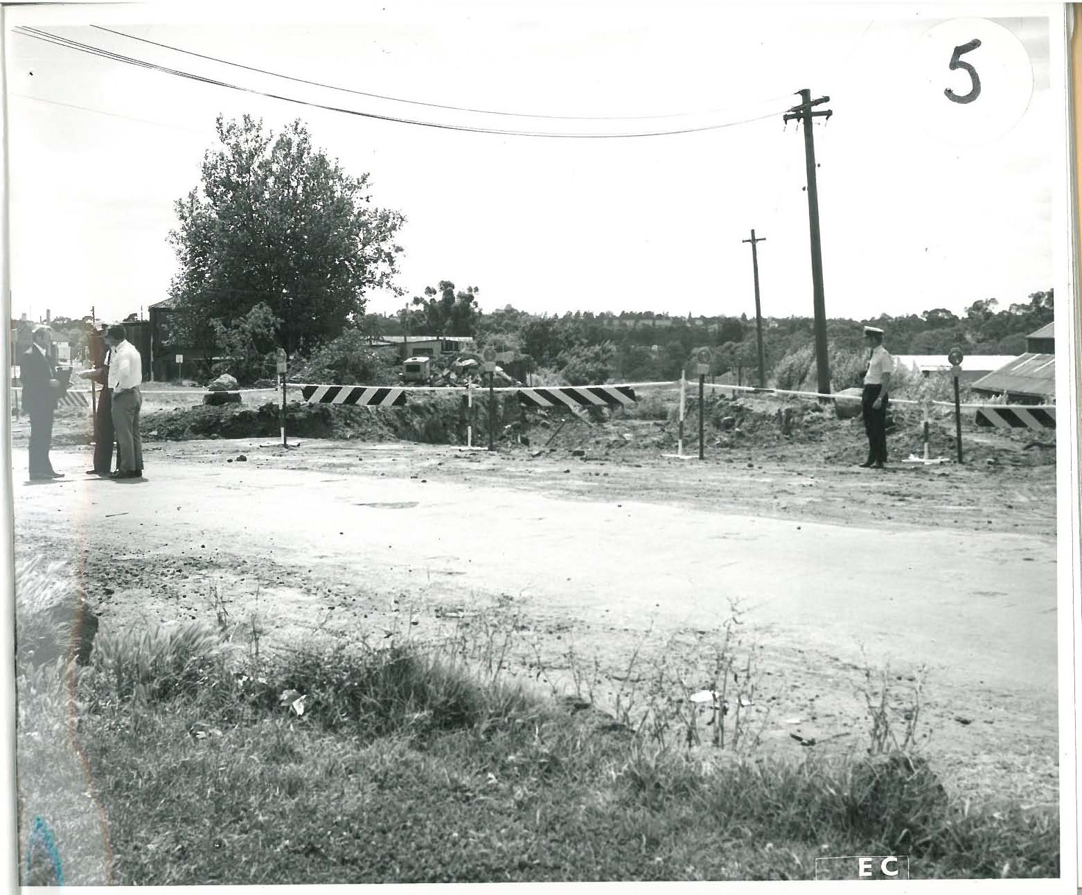 black and white photo of police standing on a dirt road